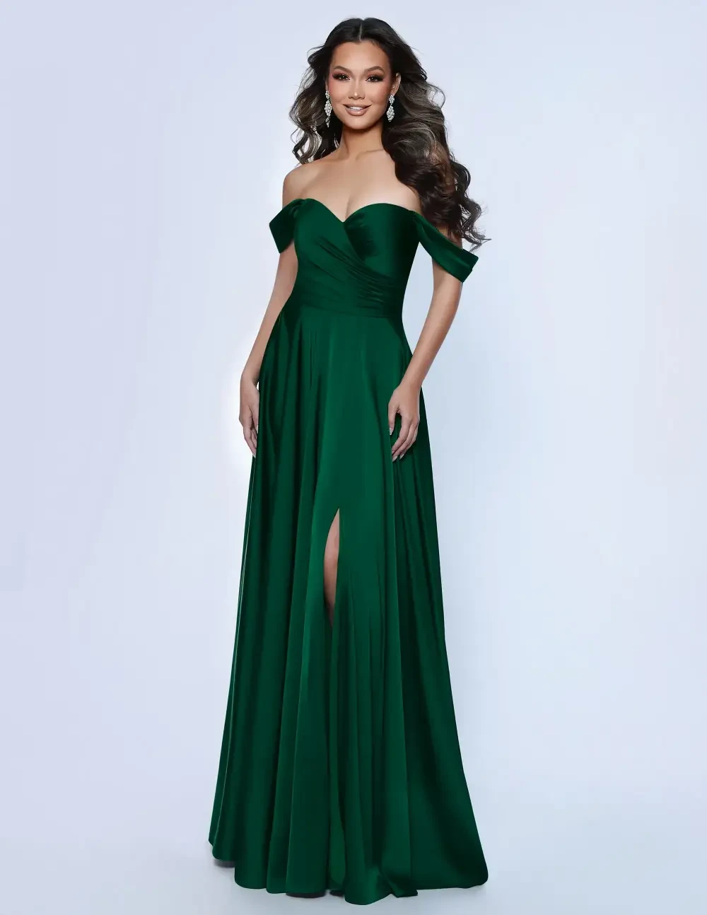 A woman in an elegant green off-the-shoulder gown with a high slit, smiling confidently.
