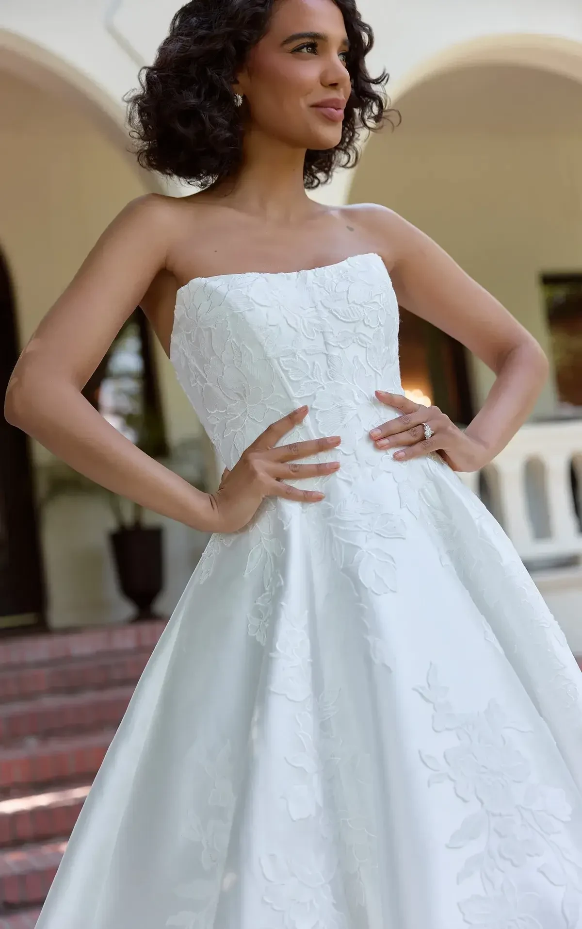 model is wearing a strapless scoop neck bridal gown