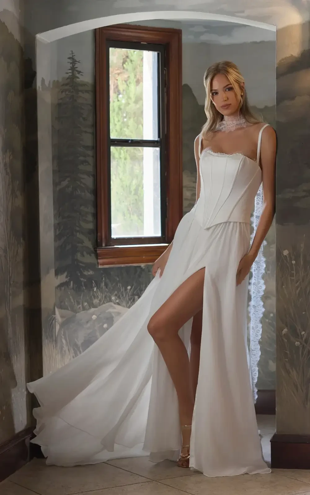 model is wearing a sleeveless bridal gown with a corset bodice