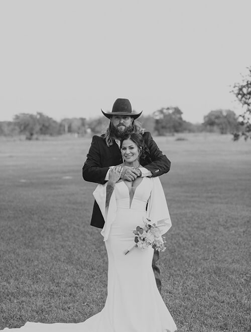 Сouple wearing a white gown and a black suit black white photo