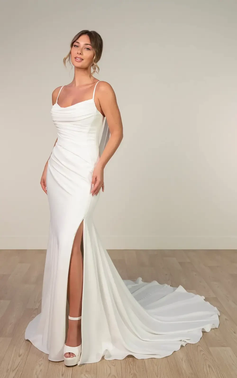 model is wearing a spaghetti strap cowl neckline bridal gown
