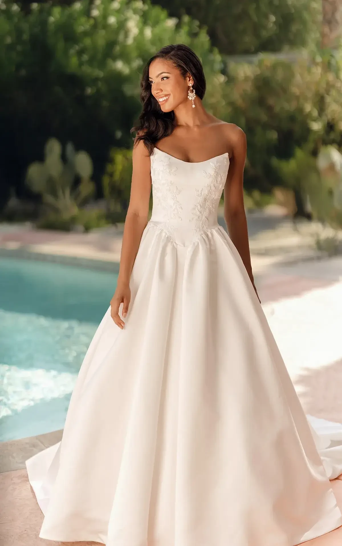 model is wearing a strapless scoop neck wedding dress
